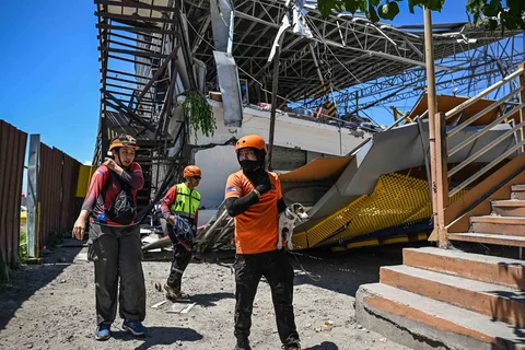 Petugas penyelamat dan seekor anjing pelacak melakukan operasi pencarian dan penyelamatan di lokasi bangunan yang runtuh setelah gempa bumi berkek magnitude 7,8 di Kota General Santos,  Filipina, Selasa (09/06/2026).