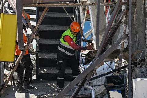 Petugas penyelamat dan seekor anjing pelacak melakukan operasi pencarian dan penyelamatan di lokasi bangunan yang runtuh setelah gempa bumi berkek magnitude 7,8 di Kota General Santos,  Filipina, Selasa (09/06/2026).