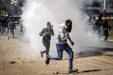 Para demonstran  berlari menghindari gas air mata  saat unjuk rasa menentang pembangunan pusat karantina Ebola yang didukung Amerika Serikat di Nanyuki, Kenya, Selasa (9/6/2026).