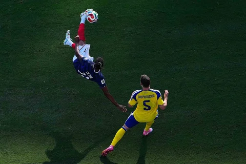 Pemain Prancis Michael Olise melakukan tendangan salto di samping pemain Swedia Gabriel Gudmundsson selama pertandingan sepak bola babak 32 Piala Dunia di East Rutherford, N.J., dekat New York, Selasa (30/06/2028).
