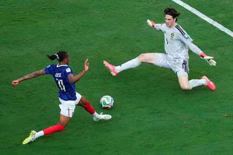 Pemain Prancis Michael Olise melakukan tendangan yang berhasil ditepis oleh kiper Swedia Jacob Widell Zetterstrom selama pertandingan sepak bola babak 32 Piala Dunia antara Prancis dan Swedia di East Rutherford, N.J., dekat New York, Selasa, (30/06/2028).