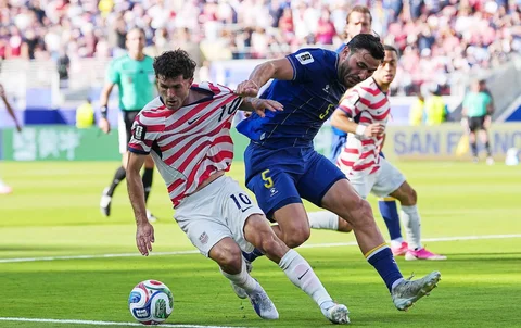 Pemain Amerika Serikat Christian Pulisic menggiring bola sementara pemain Bosnia Sead Kolasinac menarik bajunya selama pertandingan sepak bola babak 32 Piala Dunia antara Amerika Serikat dan Bosnia di Santa Clara, California, dekat San Francisco, Rabu, (01/07/2026).