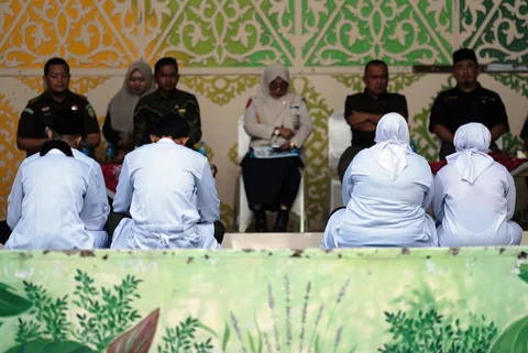 Orang-orang yang dinyatakan bersalah melanggar hukum Islam, di antaranya pasangan yang belum menikah yang terbukti berciuman saat siaran langsung TikTok, menunggu giliran untuk dicambuk di depan umum di Taman Bustanussalatin, Banda Aceh, Aceh, Kamis (2/7/2026).