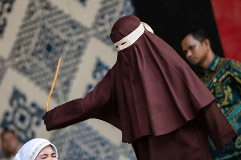 Algojo  mengeksekusi cambuk terhadap terpidana pelanggar hukum syariat Islam, diantaranya karena mencium seorang wanita saat siaran langsung TikTok, menjalani hukuman cambuk  di Taman Bustanussalatin, Banda Aceh, Aceh, Kamis (2/7/2026).