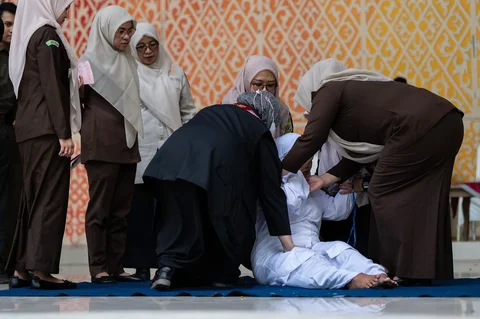 Petugas Kejaksaan Negeri Banda Aceh bersama tim medis mengangkat terpidana yang jatuh pingsan seusai menjalani hukuman cambuk bagi pelanggar hukum syariat Islam perkara bermesraan antara laki-laki dan perempuan yang bukan suami istri (ikhtilath) melalui salah satu media sosial di Taman Bustanussalatin, Banda Aceh, Aceh, Kamis (2/7/2026).