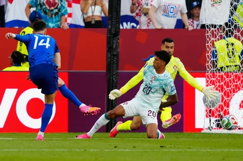 Pemain Kroasia Ivan Perisic mencetak gol melewati  pemain Porugal Joao Cancelo dan kiper Diego Costa selama pertandingan sepak bola babak 32 Piala Dunia antara Portugal dan Kroasia di Toronto, Kamis, (02/07/2026).