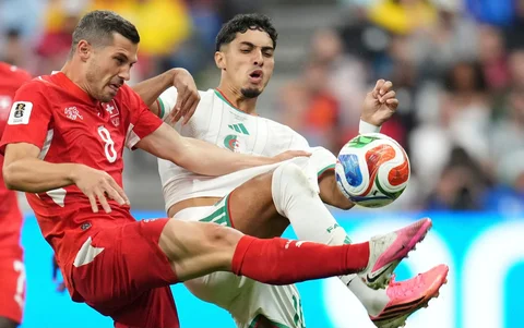 Pemain Swiss Remo Freuler berebut bola dengan pemain Aljazair Fares Chaibi selama pertandingan sepak bola babak 32 Piala Dunia antara Swiss dan Aljazair di Vancouver, British Columbia,