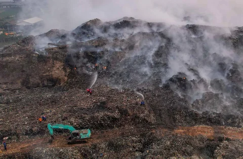 Petugas pemadam kebakaran dan alat berat  berusaha memadamkan api di Tempat Pembuangan Akhir (TPA) Jatiwaringin, Kabupaten Tangerang, Banten, Jumat (03/07/2026).