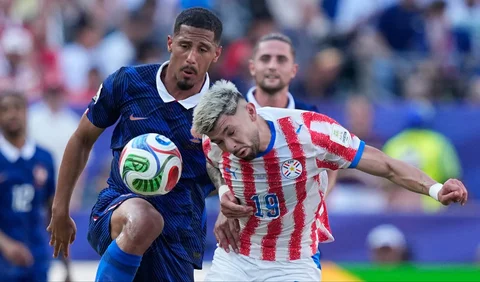 Pemain Prancis William Saliba berebut bola dengan pemain Praaguay  Julio Enciso aat pertandingan sepak bola babak 16 besar Piala Dunia di Philadelphia, Sabtu (04/07/2026).