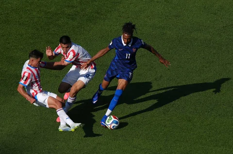 Pemain Prancis Michael Olise  berebut bola dengan pemain Paraguay Diego Gomez dan Andres Cubas  saat pertandingan sepak bola babak 16 besar Piala Dunia di Philadelphia, Sabtu (04/07/2026).