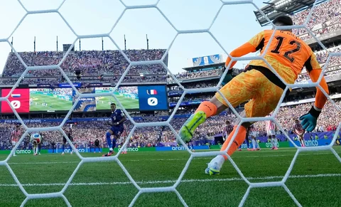 Pemain Prancis Kylian Mbappe mencetak gol dari titik penalti melewati kiper Paraguay Orlando Gill (12) saat pertandingan sepak bola babak 16 besar Piala Dunia antara Paraguay dan Prancis di Philadelphia, Sabtu (04/07/2026).