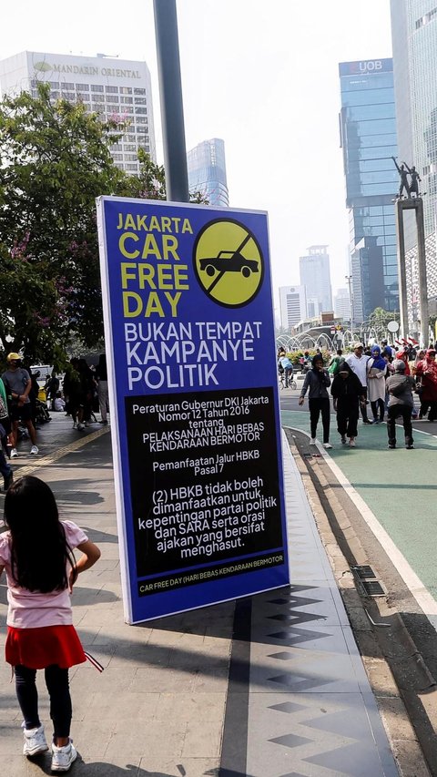 FOTO: Banner Larangan Kampanye Politik Mencuri Perhatian Saat Car Free Day di Kawasan Thamrin