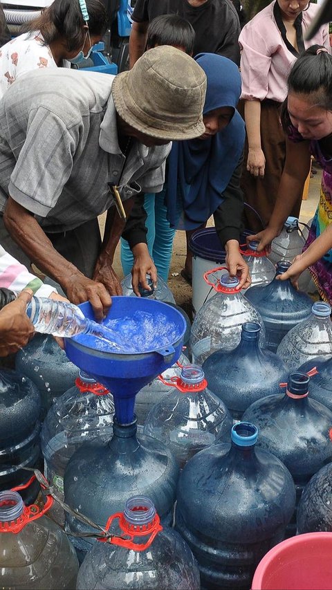 FOTO: Antusiasme Warga Pinggiran Kali Ciliwung Serbu Bantuan Air Bersih