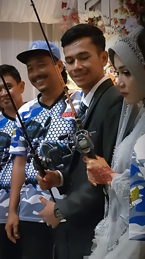 Viral! The Bride and Groom Pose While Holding Fishing Rods During a Group Photo, The Bride's Expression Becomes a Topic of Conversation