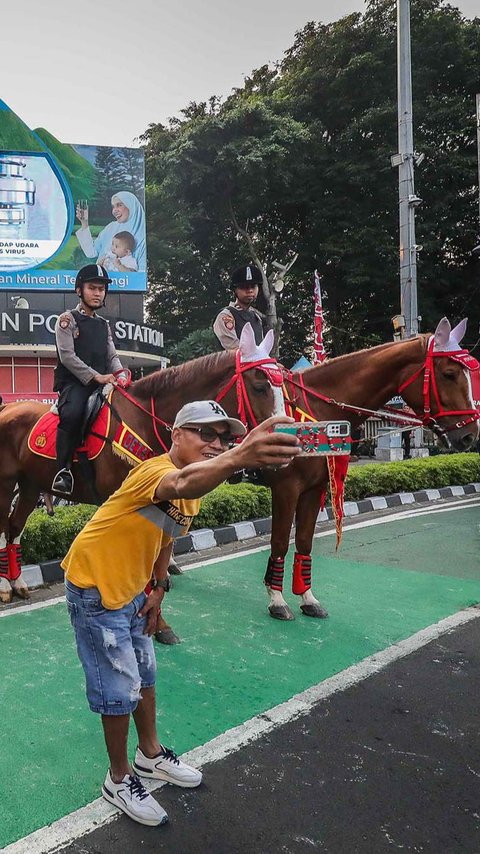 FOTO: Momen Polisi Berkuda Sapa Pengunjung CFD Jakarta, Jadi Ajang Selfie