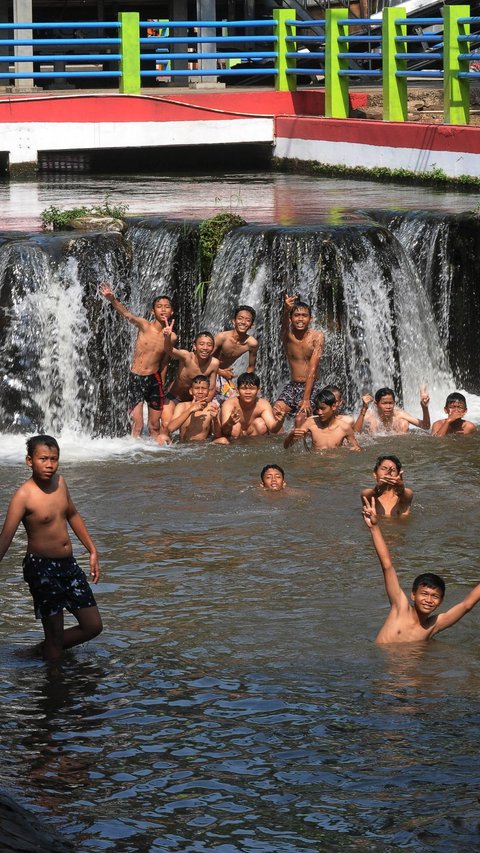 FOTO: Cuaca Panas, Anak-Anak Asyik Bermain Air di Kalimalang untuk Segarkan Tubuh