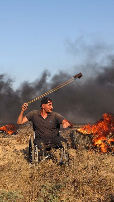 FOTO: Protes di Gaza Memanas, Pria Palestina Berkursi Roda Ini Tak Gentar Hadapi Tentara Israel