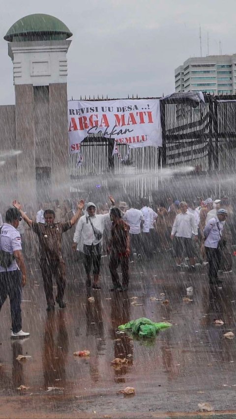 FOTO: Aksi Demo Apdesi Tuntut UU Desa Disahkan Sempat Ricuh, Water Canon Siram Massa yang Coba Robohkan Pagar DPR