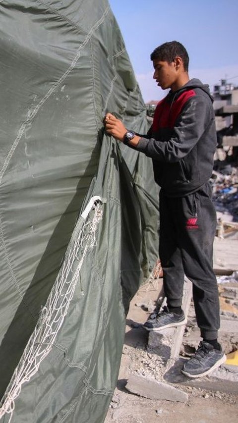 FOTO: Potret Warga Palestina Sulap Parasut Militer Jadi Tenda Darurat di Atas Puing Rumahnya