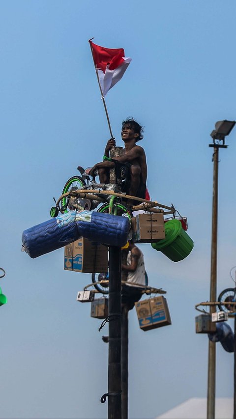 FOTO: Semarakkan HUT RI, Ratusan Orang Ikuti Lomba Panjat Pinang di Ancol Taman Impian