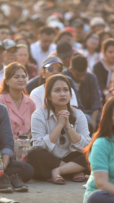 FOTO: Tak Bisa Masuk GBK, Umat Katolik Tetap Khidmat Ikuti Misa Suci Paus Fransiskus Meski Lewat Layar Lebar