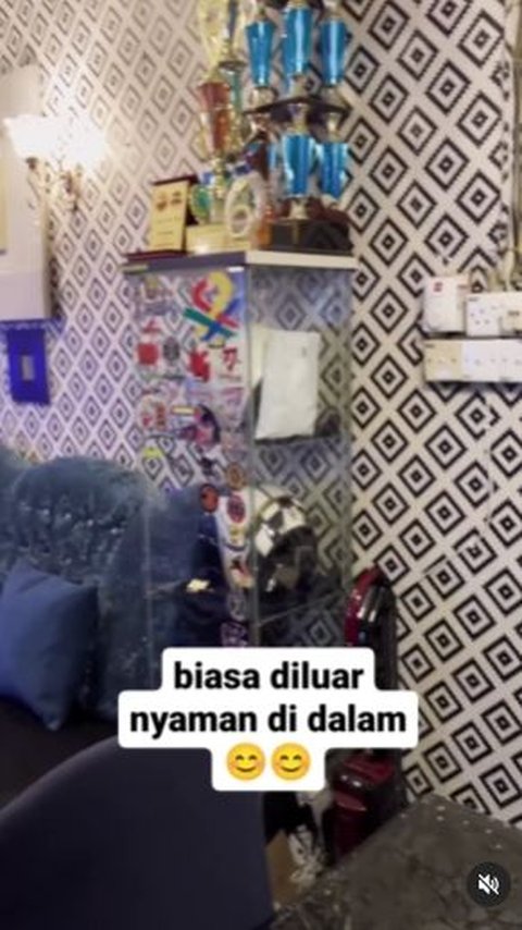 Sejumlah piala dan barang-barang berharga tampak tertata rapi dalam bingkai kaca.