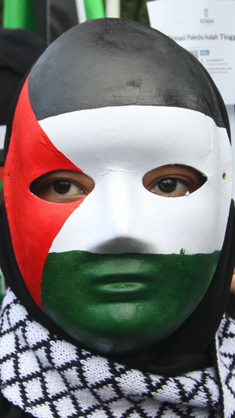Seorang peserta memakai masker dengan warna bendera Palestina saat menghadiri Aksi Bela Palestina di depan Kantor Kedubes AS, Jakarta, Sabtu (13/1/2024).
