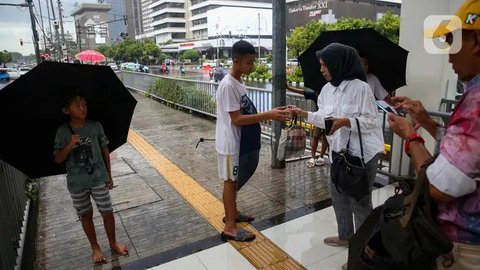 FOTO: Potret Anak-Anak Pengojek Payung di Antara Gedung Bertingkat Jakarta