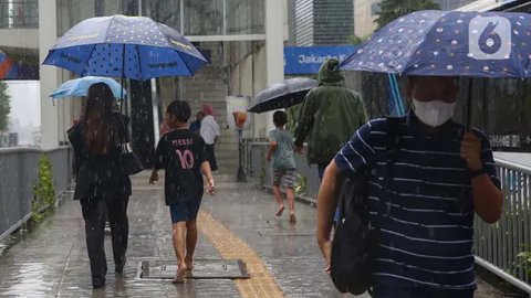 FOTO: Potret Anak-Anak Pengojek Payung di Antara Gedung Bertingkat Jakarta