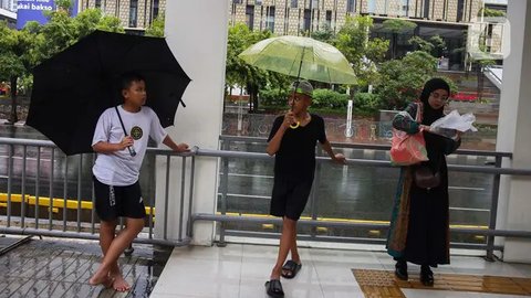 FOTO: Potret Anak-Anak Pengojek Payung di Antara Gedung Bertingkat Jakarta