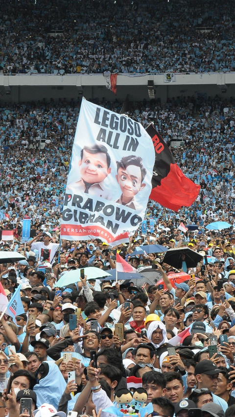 Tampak massa pendukung Prabowo-Gibran membentangkan spanduk saat menghadiri Kampanye Akbar di GBK. Foto: merdeka.com / Imam Buhori<br>