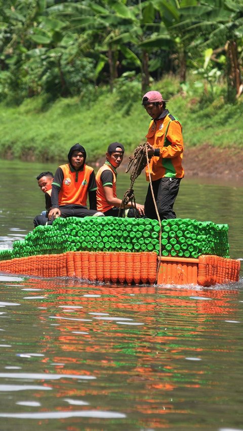 Petugas UPS Badan Air saat melakukan uji coba ketahanan dan keseimbangan perahu botol plastik bekas di aliran KBT. Foto: merdeka.com / Imam Buhori