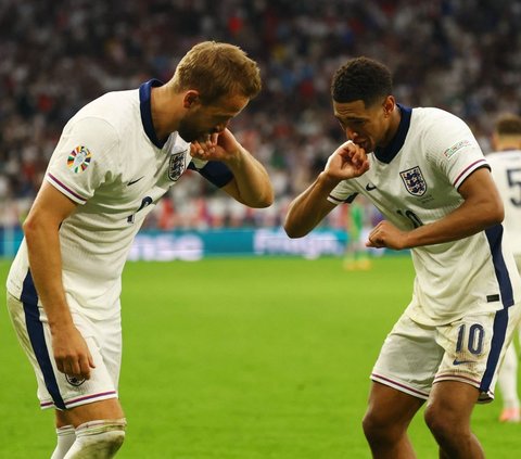 Pemain Timnas Inggris, Harry Kane dan Jude Bellingham melakukan selebrasi saat bertanding melawan Slovakia dalam babak 16 besar Euro 2024 di Stadion Arena AufSchalke, Gelsenkirchen, Jerman, pada Minggu (30/6/2024). Inggris secara dramatis menumbangkan Slovakia lewat comeback maut dengan skor 2-1. Foto: Reuters