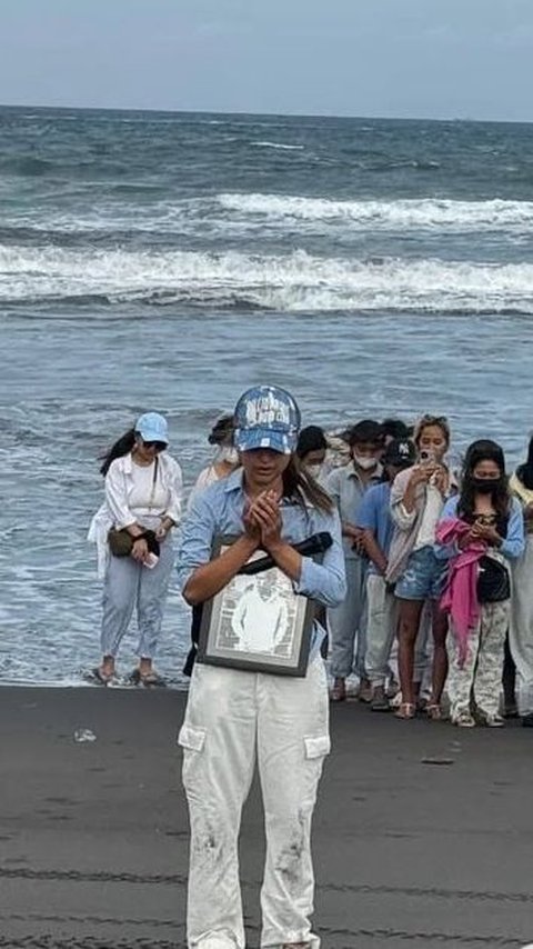 Tak hanya memakai kalung, Jennifer juga membawa topi kesayangan sang suami.