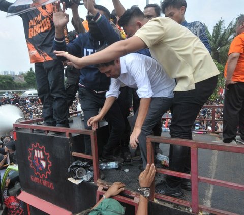 Setelah hadir menemui para demonstran tolak RUU Pilkada, anggota DPR dari Fraksi Gerindra Habiburokman tampak dilindungi sejumlah orang saat akan turun dari atas mobil komando di depan Gedung DPR, Jakarta, Kamis (22/8/2024). Foto: merdeka.com / Imam Buhori