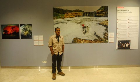 Pewarta Foto Merdeka.com, Arie Basuki berpose di depan karyanya yang berjudul “Pollution in the Cileungsi River” saat pameran World Press Photo (WPP) 2024 di Pusat Kebudayaan Belanda Erasmus Huis, Jakarta, Sabtu (24/8/2024). <br>