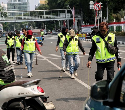 Sekelompok relawan sapu bersih (saber) ranjau paku terlihat turun ke jalan pada Rabu (4/9/2024). Mereka menyisir jalanan yang akan dilintasi rombongan Pemimpin Tertinggi Gereja Katolik Sedunia, Paus Fransiskus. Foto: Liputan6.com/Angga Yuniar