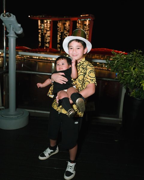 Potret Gemas Rafathar Gendong Baby Lily saat Malam Tahun Baru di Singapura, Ekspresinya Bikin Netizen Tersentuh