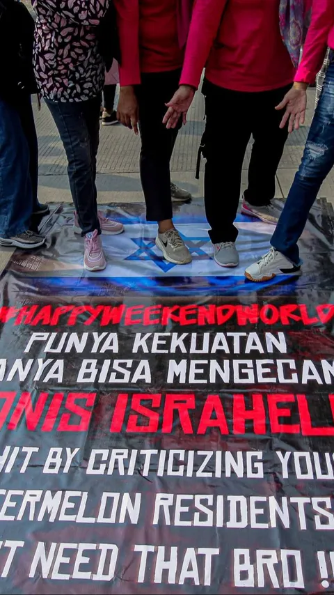 FOTO: Kutuk Serangan Pasukan Zionis, Warga Jakarta Ramai-Ramai Injak Spanduk Bendera Israel Saat CFD Sudirman-Thamrin