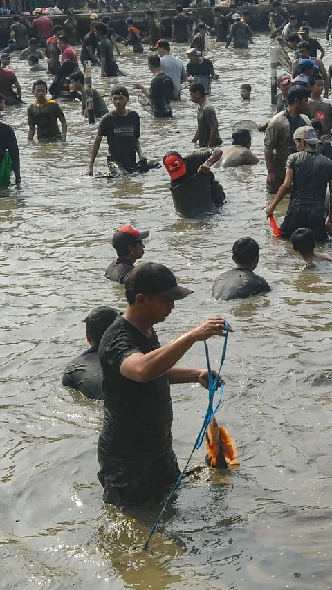 FOTO: Antusiasme Warga Berebut Ikan Saat Tradisi Ngubek Empang Jelang Lebaran Depok