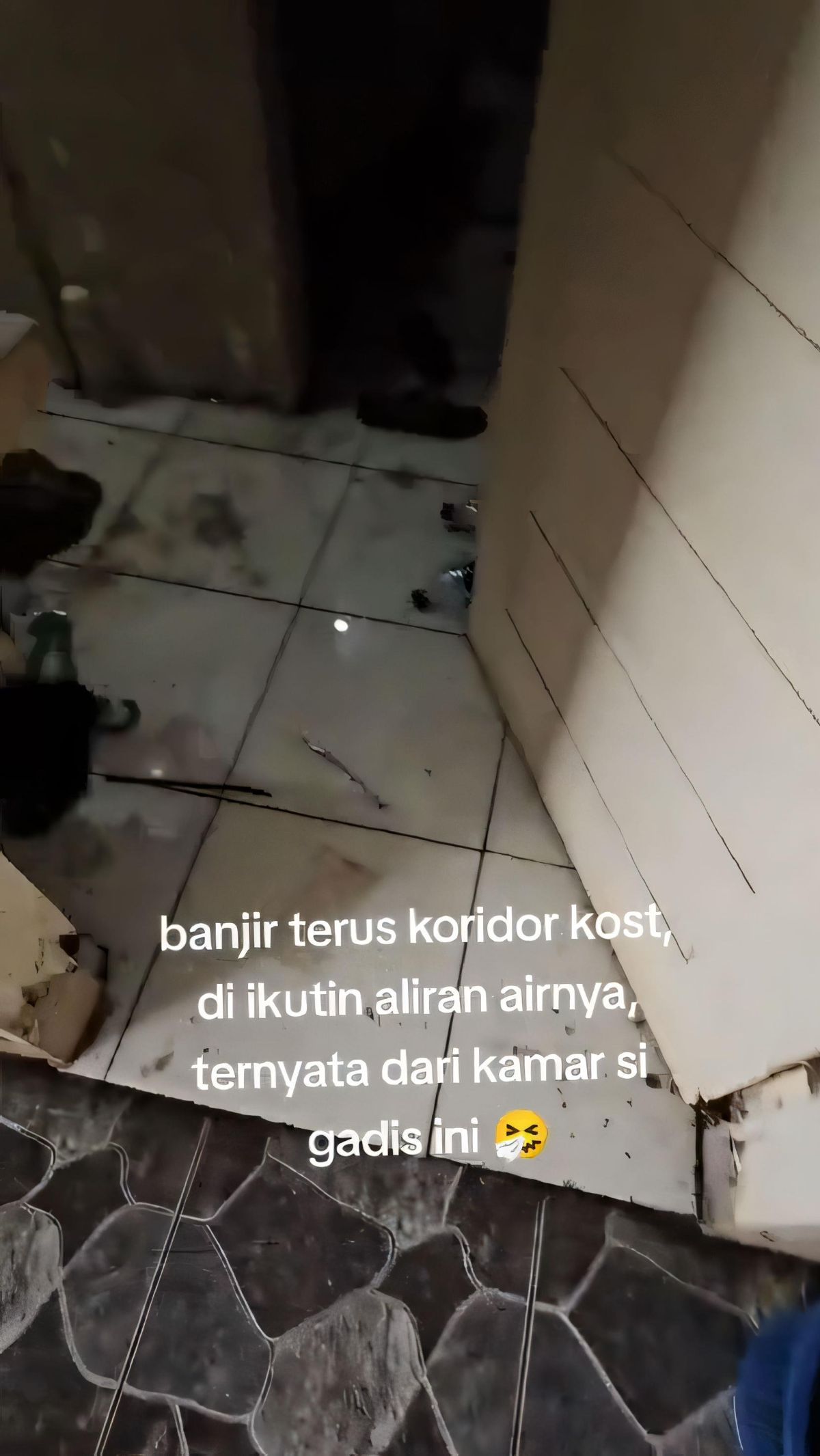 Tampak area depan kamar kos itu sangat kotor. Sampah berupa botol minuman berserakan di lantai.
