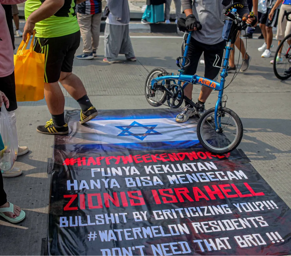 FOTO: Kutuk Serangan Pasukan Zionis, Warga Jakarta Ramai-Ramai Injak Spanduk Bendera Israel Saat CFD Sudirman-Thamrin