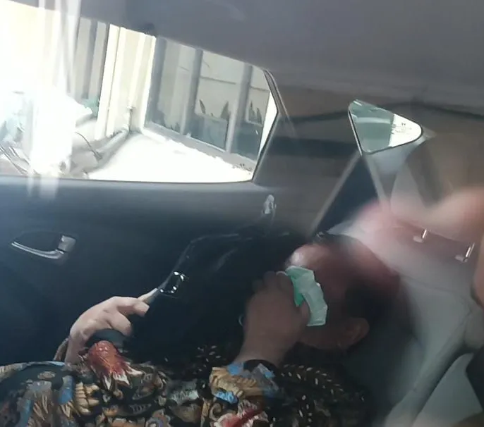Firli terlihat menghindari sorotan kamera awak media. Firli kedapatan bersembunyi di dalam mobilnya, menunduk dan menutupi kedua wajahnya dengan tas. Firli yang menggunakan batik warna cokelat duduk di belakang sopir.