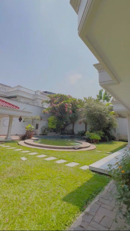 Rumah itu juga sangat luas dengan taman belakang yang super luas dan rapi. Taman ditumbuhi rerumputan hijau.