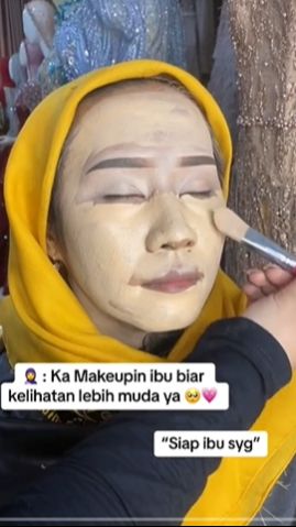 Makeup Artist (MUA) itupun mengaplikasikan foundation dengan tebal ke arah wajah sang klien menggunakan kuas.