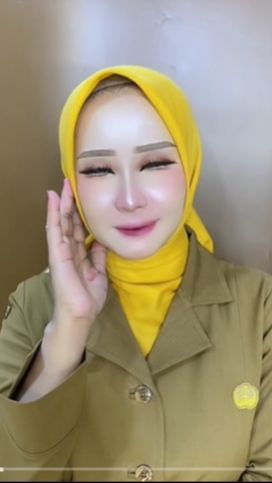Perpaduan seragam berwarna cream dengan kerudung kuning yang dikenakan pun semakin menambah kesan cerah pada bagian wajahnya.