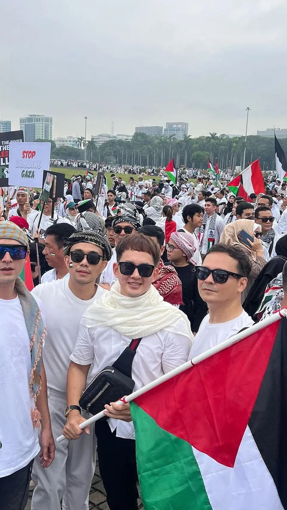 Kiki Farel tampak hadir mengenakan busana serba putih lengkap dengan bendera Palestina.