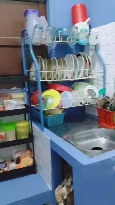 Wallpaper dapur itu diganti gelas piring pun ditata di dalam rak dengan rapi.