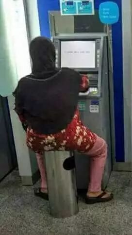 Adapula si Ibu yang santai duduk diatas tong sampah.