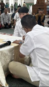 Helmy tampak sedang mendampingi calon menantunya itu menjalani prosesi untuk menjadi mualaf.